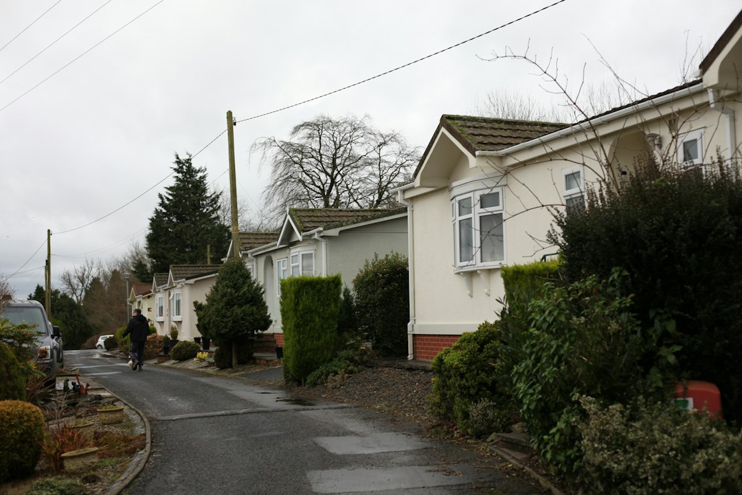 A clear, professional shot of two distinct residential homes side-by-side, visually representing the choice between different real estate service models for a homeowner.