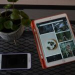 Close-up of a tablet and smartphone displaying a modern luxury home, illustrating a multi-device digital real estate marke...