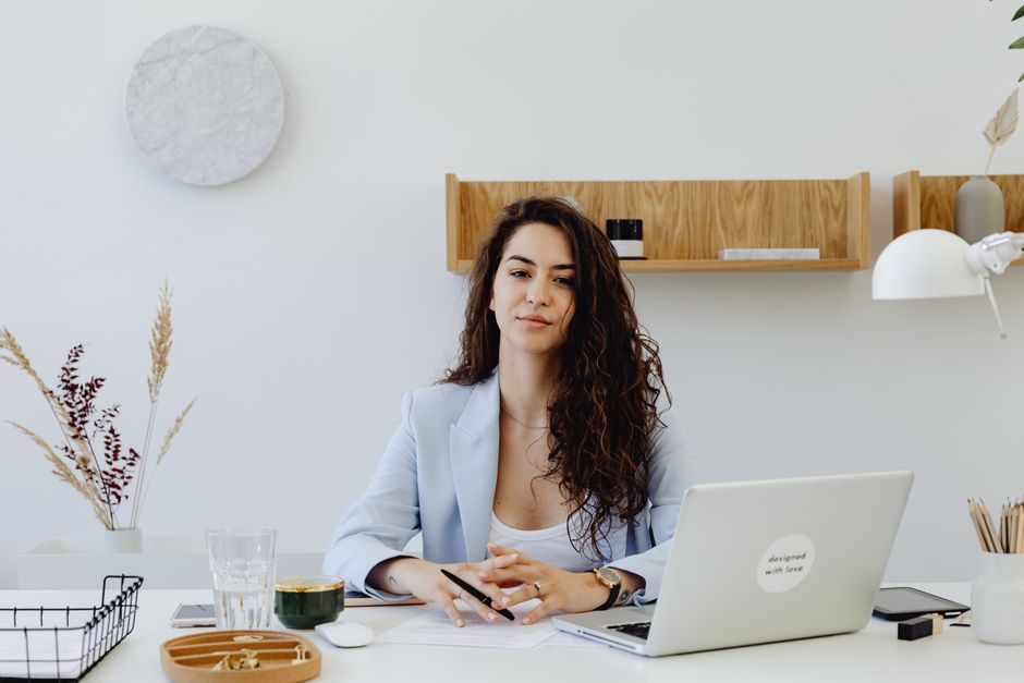 A professional real estate agent works on a laptop in a clean, modern office, symbolizing the strategic digital marketing plan used to sell a home.