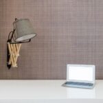 Clean, modern desk setup featuring a laptop, blueprints, and a miniature architectural model of a house, symbolizing real ...